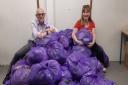 Kim Smith (left) and Kathie Reilly (right) with the donated bag of clothes used to raise money for Cancer Research UK.