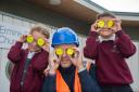 Charlie Keene from David Wilson Homes and pupils have fun with the new bag tags.