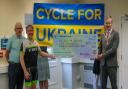 St Neots Cycle Club member Mike Colmar and Graham Temple, from the Archer Road Club, in St Ives handing the cheque to Cllr Ben Pitt.