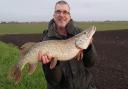 Mick Bartlett with his pike caught on a Fenland drain.