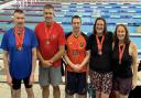 Five of the six Huntingdon Piranhas masters swimmers celebrate with their impressive medal haul.