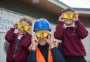 Charlie Keene from David Wilson Homes and pupils have fun with the new bag tags.