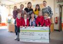 Pupils form Priory Infant School accepting a cheque from David Wilson Homes