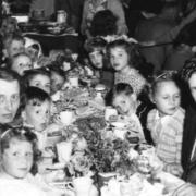 Children and family eating and celebrating during a Coronation party on East Street, St Neots, in 1953.