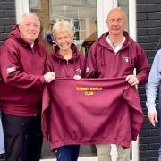 Ramsey Bowls Club members (middle) proudly display the new hoodies next to Dizzy (right) and his assistant Harry (left).