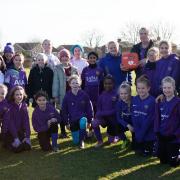 Huntingdon Girls Football Club stand proudly with their new defibrillator.