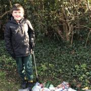 Elijah Hearn, 9, proudly showing off his impressive litter picking haul from the Co-op car park bushes in St Ives.