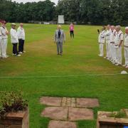 The two teams in the Philip Gillet memorial match at Waresley Cricket Club listen to a speech from John Gillett.