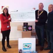 Founder of Shining Stars Children's Charity Natalie Sparrow receives a cheque from Rotary president Steve McCallion and Rotarian Mike Andrews.