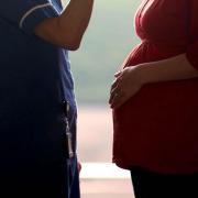 Stock photograph of a healthcare worker speaking to an expectant mother.
