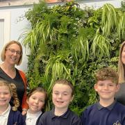 (From L to R) teacher Liz Harman, Izzy, Eva, Alex & Noah from the Eco Council and Emma Cohen from Trime UK with the 'Living Wall' situated in the foyer of the primary school.
