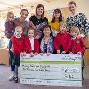 Pupils form Priory Infant School accepting a cheque from David Wilson Homes